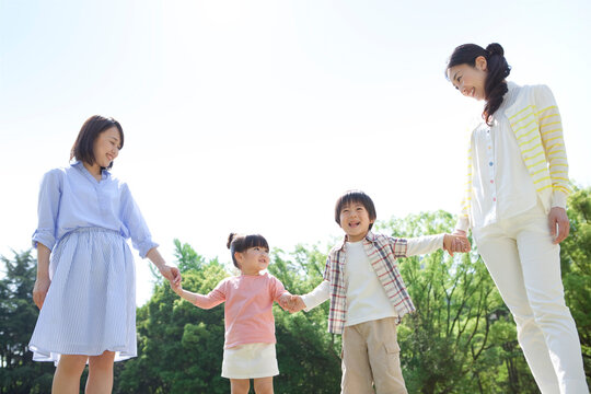 手をつないでいる2組の親子