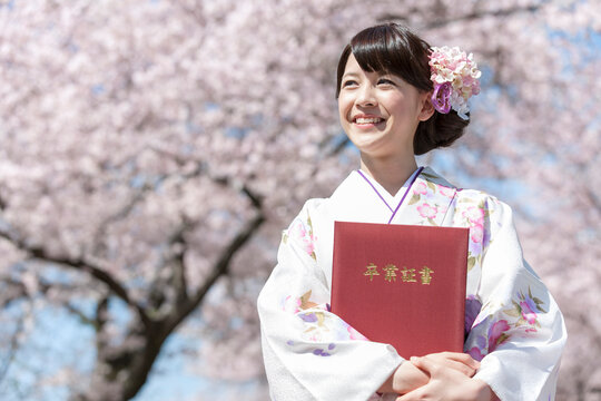 卒業証書を持つ袴姿の女子大生