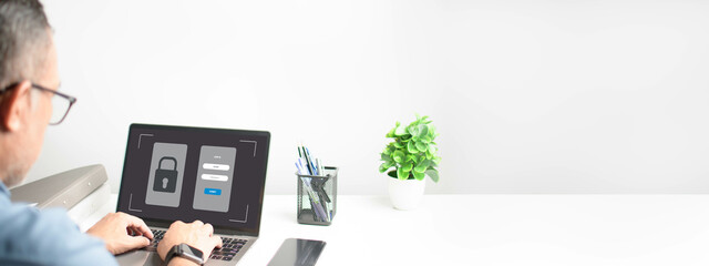 Men typing on a keyboard to use computer network. Laptop screen showing login for security system. Concept work at home with computers and Internet. Notebook computer on a white table. blur background