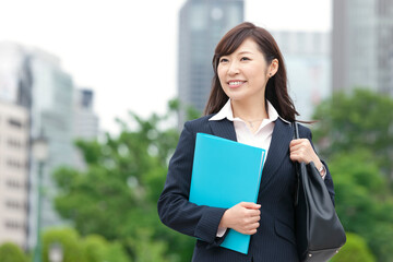 ファイルとカバンを持つビジネスウーマン