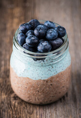 Healthy chia pudding with blueberries in jar on the rustic background. Selective focus. Shallow depth of field.