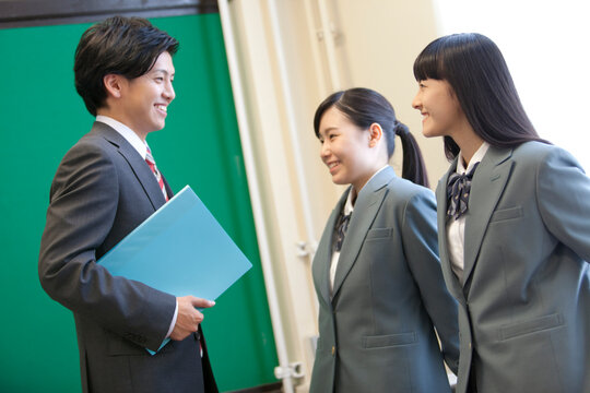 話をしている女子校生と先生