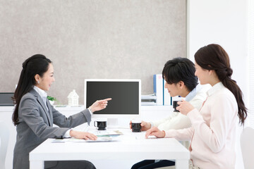 説明をするビジネスウーマンと夫婦