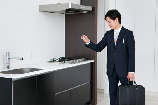キッチンの写真を撮るビジネスマン