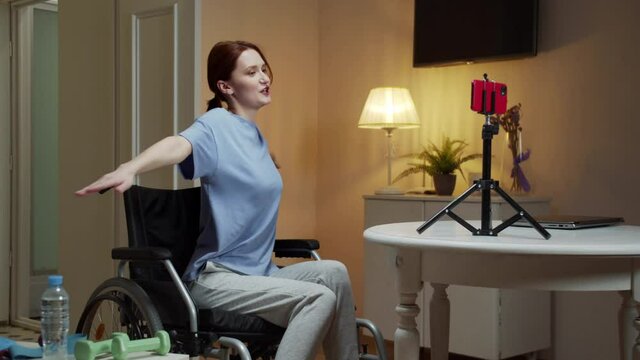 A disabled woman is spreading her arms in different sides 