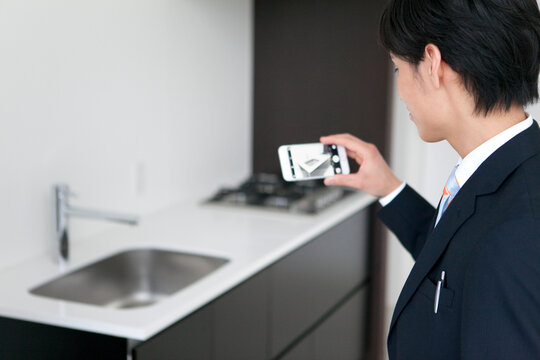 キッチンの写真を撮るビジネスマン