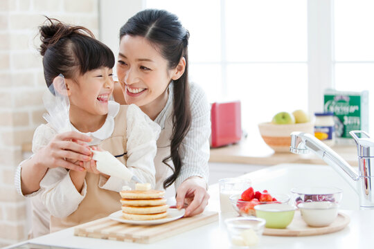 ホイップクリームを絞る女の子と母親