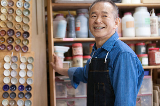 エプロンをつけた笑顔のシニア男性