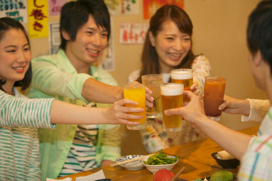 居酒屋で乾杯する若者
