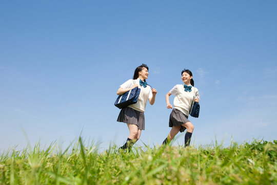 芝生を走る女子校生2人