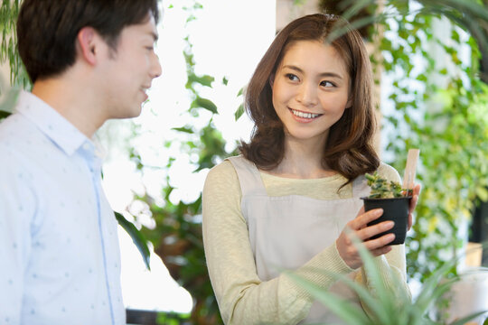 花屋で働く女性店員と客