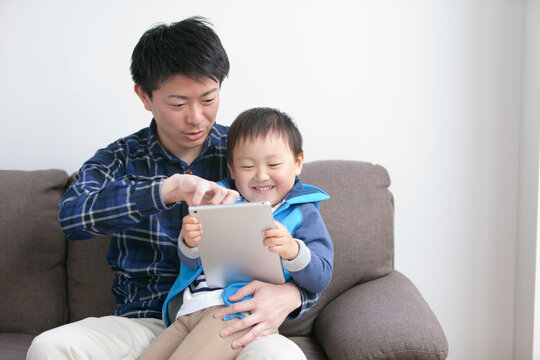 タブレットPCを見る男の子と父親
