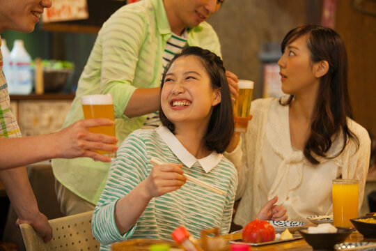 居酒屋で食事をする若者