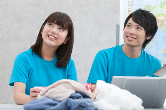 ノートパソコンを見て話す男女