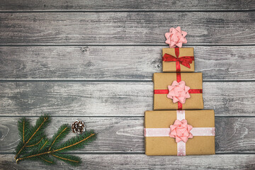 Holiday gifts and a sprig of a Christmas tree on a wooden background. New Year and Christmas concept. Flat lay