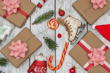 Holiday gifts, lollipops, branches of a Christmas tree and toys on a white wooden background. New Year and Christmas concept. Flat lay