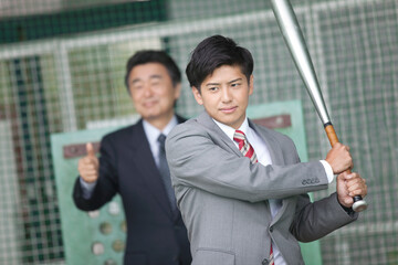 バッティングセンターにいるビジネスマン2人