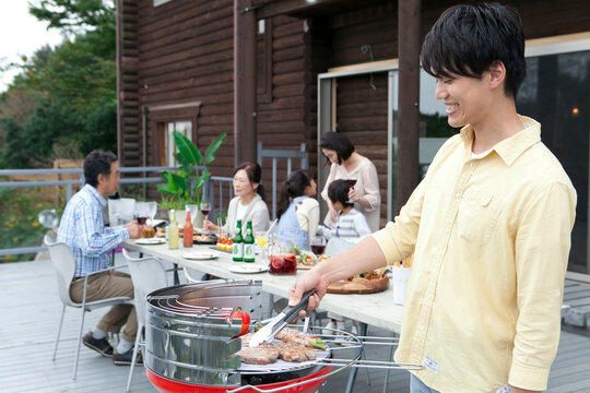 バーベキューをする3世代家族