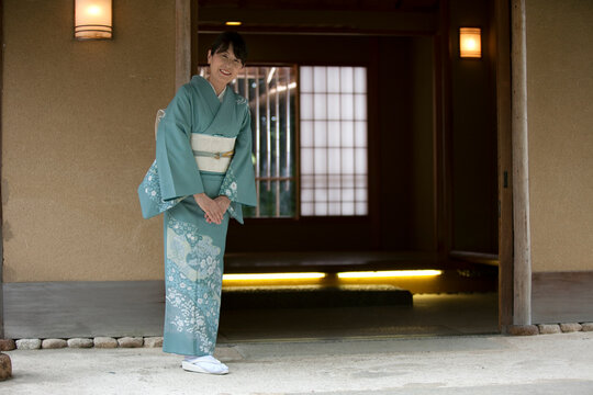 玄関で挨拶する中高年女性