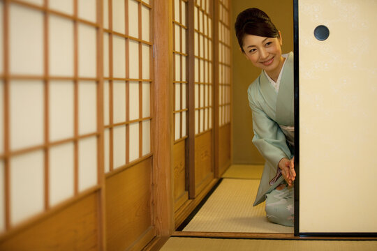 襖を開ける着物姿の女性