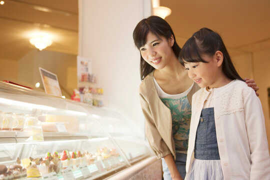 ケーキのショーケースを見る母娘