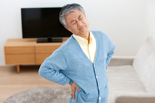 腰を押さえる中高年男性