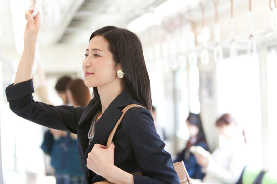 通勤電車に乗っているビジネスウーマン