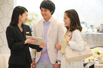 打ち合わせをするウエディングプランナーとカップル