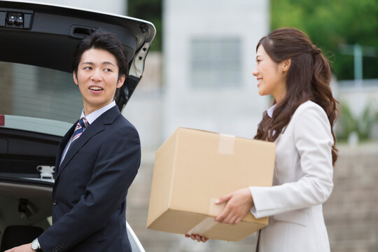 荷物を運ぶビジネス男女