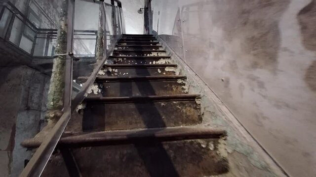 Camera moves up stairs to overlook cellblock at Eastern State Penitentiary.