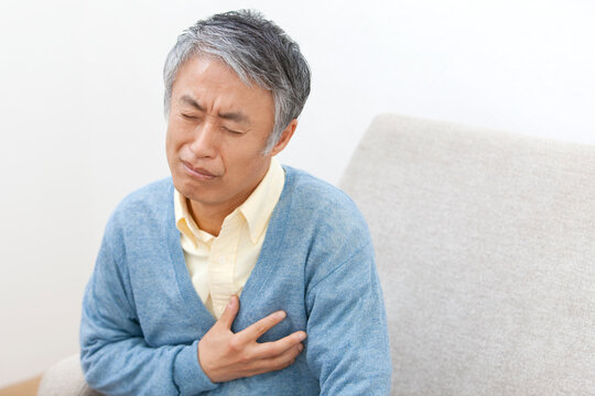 胸を押さえる中高年男性