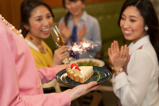 ケーキでお祝いする女性4人