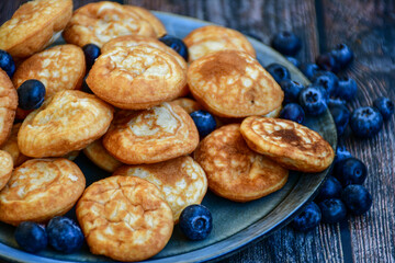 Homemade Dutch Poffertjes  Mini Pancakes with butter , Powdered Sugar  and blueberries