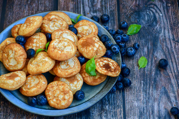 Homemade Dutch Poffertjes  Mini Pancakes with butter , Powdered Sugar  and blueberries