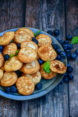 Homemade Dutch Poffertjes  Mini Pancakes with butter , Powdered Sugar  and blueberries