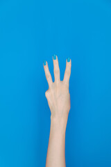 hand showing number three In front of the blue background