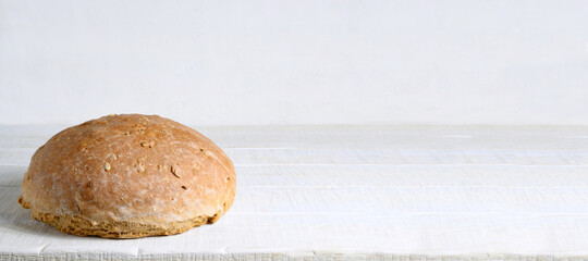 Homemade bread on white rustic wooden table with copy space. Banner
