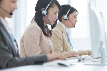 インカムで話をしながらPCを使う女性オペレーター