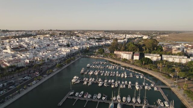 Aerial pullback Ayamonte marina reveal Coastal Spanish village, white house Landscape