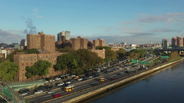 aerial shot follows cars uptown on the Harlem River Drive in New York City, schoolbuses in interest