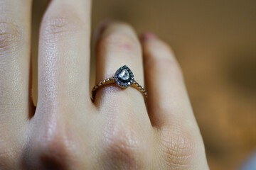 Solitaire diamond ring, water drop shaped solitaire diamond ring on finger, top view close up macro photo