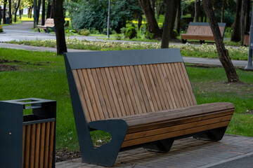 wooden bench in the park
A bench in a city park without people. Place of rest for the townspeople when walking in the park.