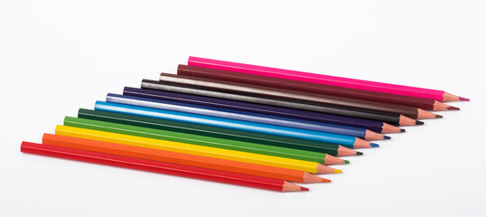 a set of colored pencils lies in a row on a white background