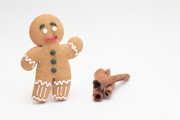 Cookie gingerbread with cinnamon sticks on white background.