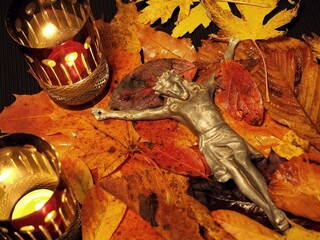 Fototapeta Cmentarny krucyfiks w jesiennych liściach i znicz obraz