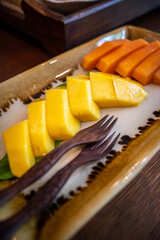 Close up on yellow mango on fruit dish.