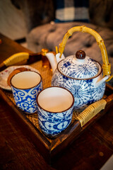 Close focus on striped blue and white ceramic cup with set of kettle.