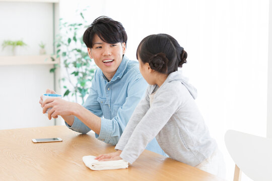 テーブルを拭く女の子と父親