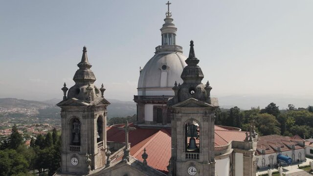 Close up pan shot capturing the clock bell towers and dome monumental sanctuary of sameiro.