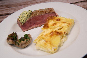 Recipe for gratin dauphinois, grilled veal steak and grilled button mushroom. High quality photo